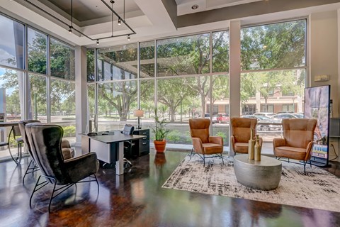 A living room with a black chair and a brown chair facing a window.